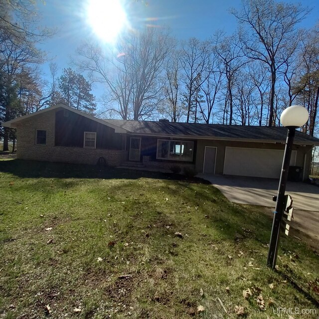9014 Stagecoach Q.5 Ave, Gladstone, MI 49837 - view of front of property featuring a front yard, concrete driveway, and a garage