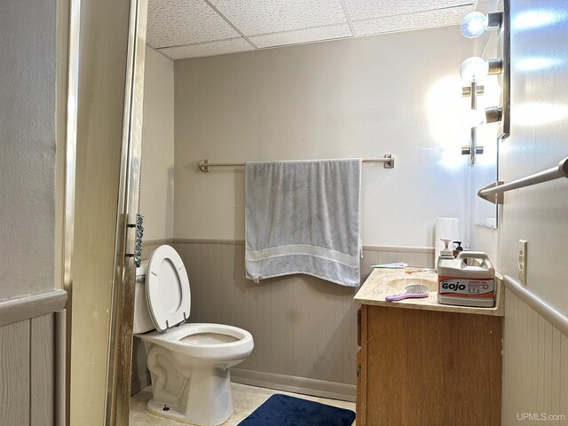 9014 Stagecoach Q.5 Ave, Gladstone, MI 49837 - bathroom featuring wainscoting, toilet, a drop ceiling, and tile patterned floors