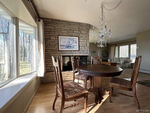 9014 Stagecoach Q.5 Ave, Gladstone, MI 49837 - dining room with a brick fireplace, baseboards, light wood-type flooring, and a chandelier
