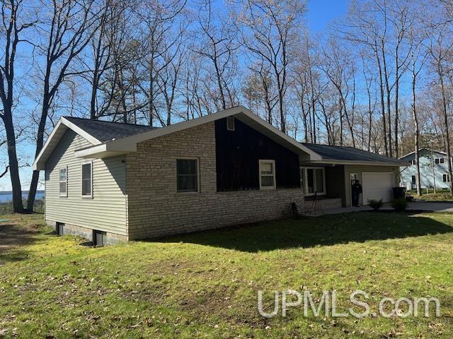 9014 Stagecoach Q.5 Ave, Gladstone, MI 49837 - view of front of home with an attached garage, a front yard, and driveway