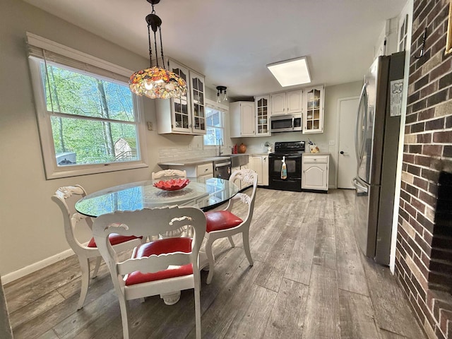 555 W Saxton Rd, Sanford, MI 48657 - dining space with light wood-style floors and baseboards