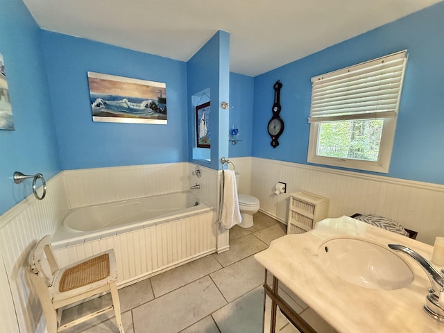 555 W Saxton Rd, Sanford, MI 48657 - bathroom featuring wainscoting, toilet, tile patterned flooring, a garden tub, and vanity