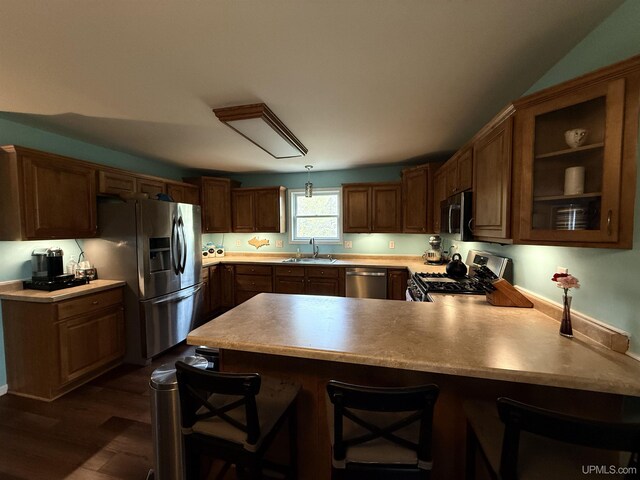 1300 W Sharon Ave, Houghton, MI 49931 - kitchen with appliances with stainless steel finishes, a sink, a peninsula, light countertops, and dark wood-style flooring