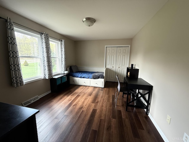 1300 W Sharon Ave, Houghton, MI 49931 - bedroom with dark wood-type flooring, a closet, baseboards, and an office area