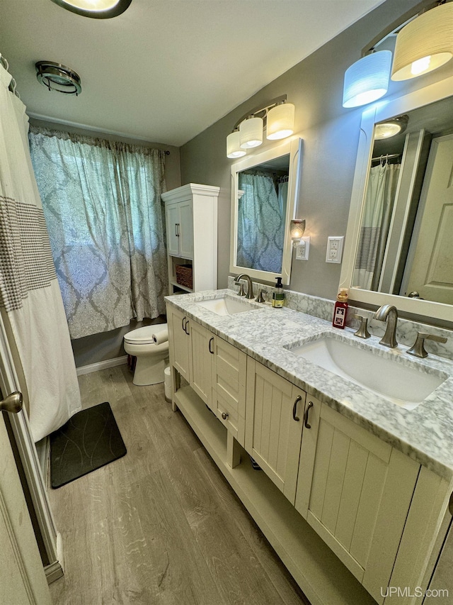 900 Wabash St, Ishpeming, MI 49849 - full bath featuring wood finished floors, double vanity, and toilet