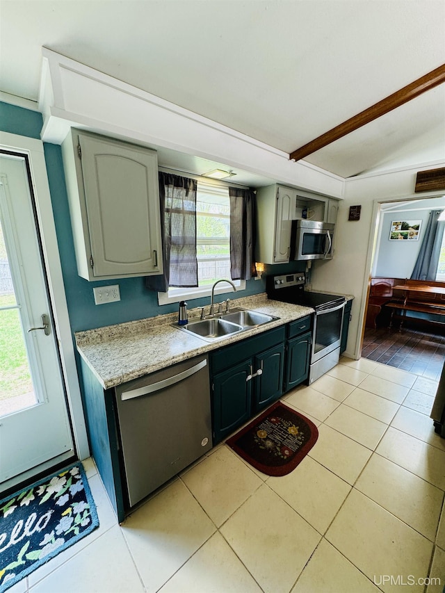 900 Wabash St, Ishpeming, MI 49849 - kitchen featuring appliances with stainless steel finishes, a sink, light tile patterned floors, light countertops, and vaulted ceiling