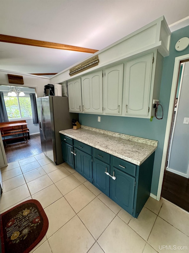900 Wabash St, Ishpeming, MI 49849 - kitchen with stainless steel refrigerator with ice dispenser, light countertops, light tile patterned flooring, and baseboards