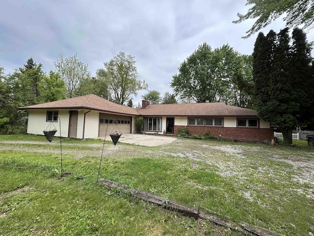 63150 Mound Rd, Washington Twp, MI 48095 - back of property featuring a garage, a chimney, concrete driveway, a lawn, and brick siding