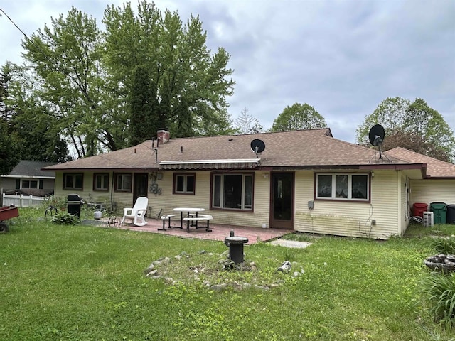 63150 Mound Rd, Washington Twp, MI 48095 - rear view of house featuring a patio area, a lawn, and roof with shingles