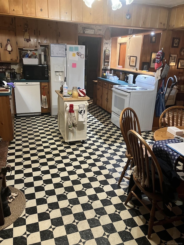 63150 Mound Rd, Washington Twp, MI 48095 - kitchen featuring white appliances, washer / dryer, tile patterned floors, dark countertops, and wooden walls