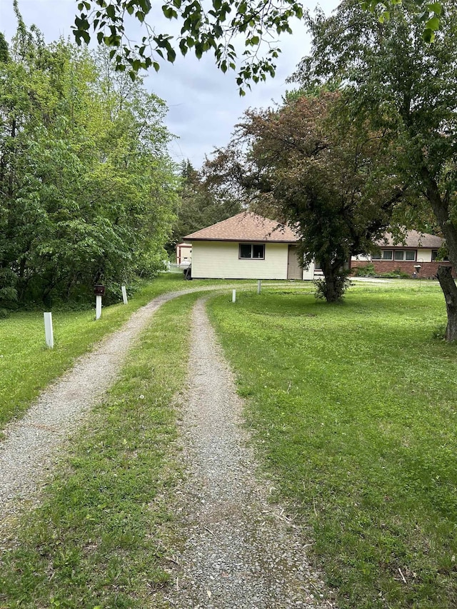 63150 Mound Rd, Washington Twp, MI 48095 - view of home's exterior featuring dirt driveway, a lawn, and stucco siding