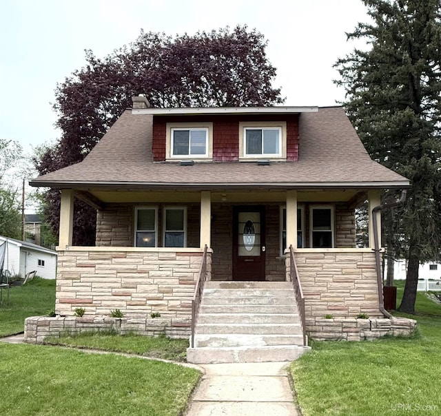 404 W Ludington St, Iron Mountain, MI 49801 - bungalow-style house featuring stone siding, covered porch, a front lawn, and roof with shingles