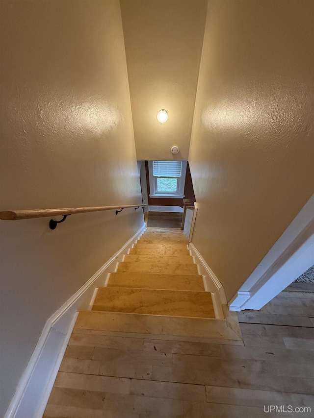 404 W Ludington St, Iron Mountain, MI 49801 - stairs featuring hardwood / wood-style flooring, baseboards, and vaulted ceiling