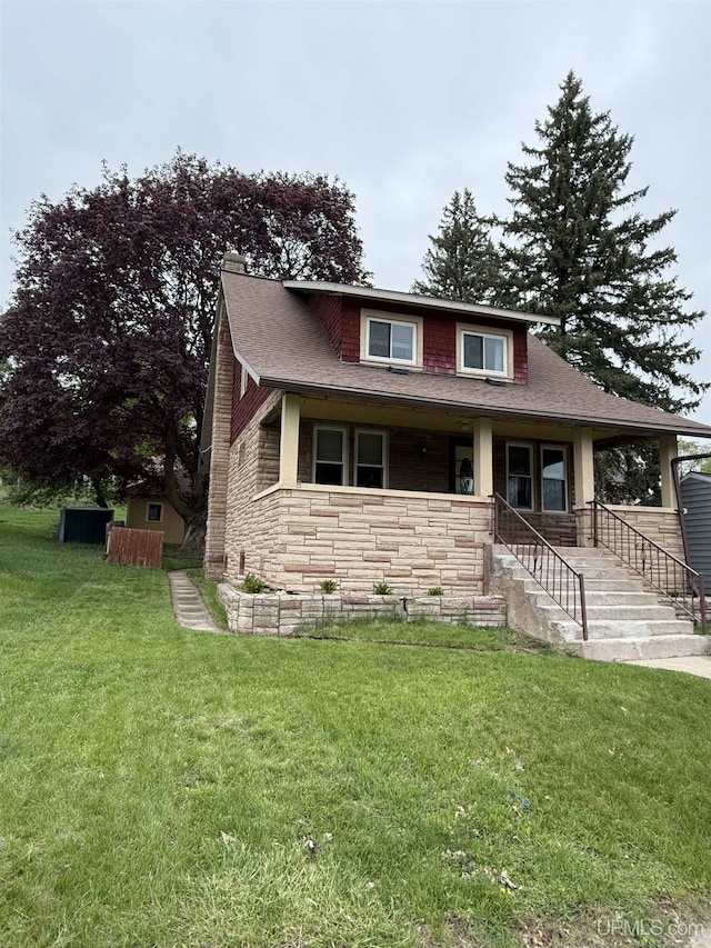 404 W Ludington St, Iron Mountain, MI 49801 - bungalow-style house featuring stone siding, a porch, a front yard, a chimney, and roof with shingles