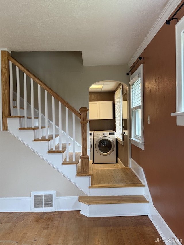 404 W Ludington St, Iron Mountain, MI 49801 - stairs featuring arched walkways, separate washer and dryer, and baseboards
