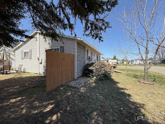 99 N Mitchell St, Gwinn, MI 49841 - view of side of home featuring stone siding and a lawn