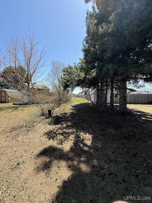 99 N Mitchell St, Gwinn, MI 49841 - view of yard with a storage unit, an outdoor structure, and fence