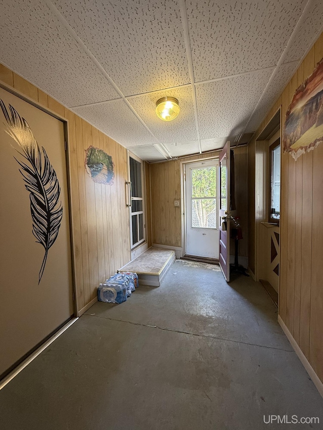 99 N Mitchell St, Gwinn, MI 49841 - unfurnished dining area with wooden walls, concrete floors, and baseboards