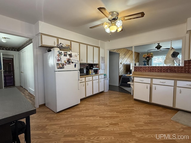 99 N Mitchell St, Gwinn, MI 49841 - kitchen featuring freestanding refrigerator, a ceiling fan, light wood-style flooring, and white cabinetry