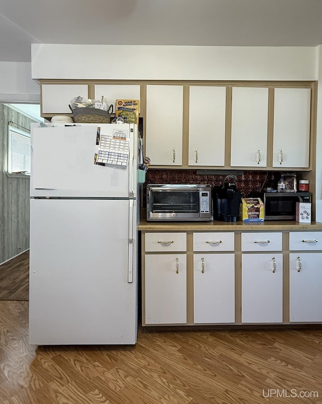 99 N Mitchell St, Gwinn, MI 49841 - kitchen with freestanding refrigerator, stainless steel microwave, and wood finished floors