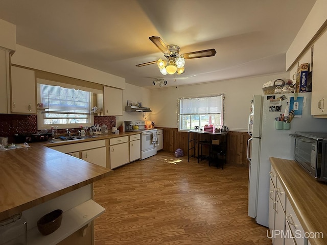 99 N Mitchell St, Gwinn, MI 49841 - kitchen featuring white appliances, butcher block counters, light wood-style flooring, a wainscoted wall, and a sink