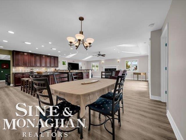 dining area with a chandelier, baseboards, light wood-type flooring, a ceiling fan, and recessed lighting