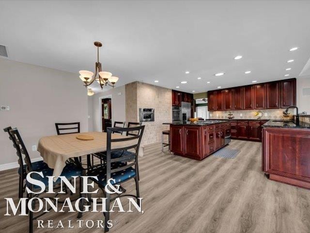 dining space with light wood-style flooring, a chandelier, recessed lighting, and baseboards