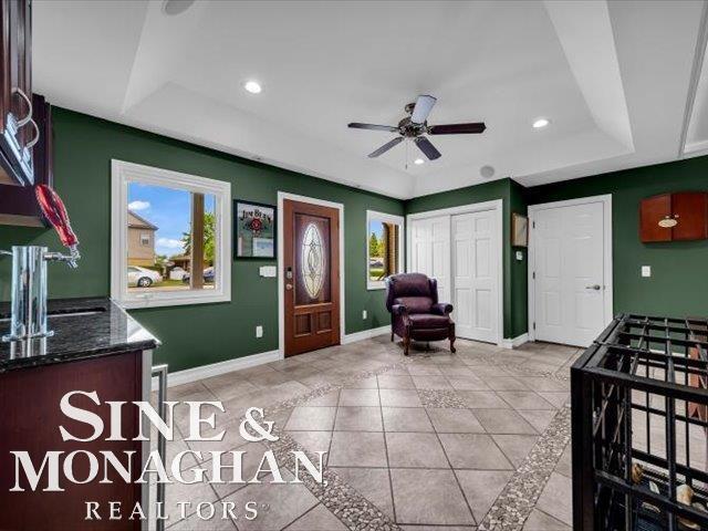 entrance foyer with a raised ceiling, baseboards, ceiling fan, recessed lighting, and light tile patterned floors