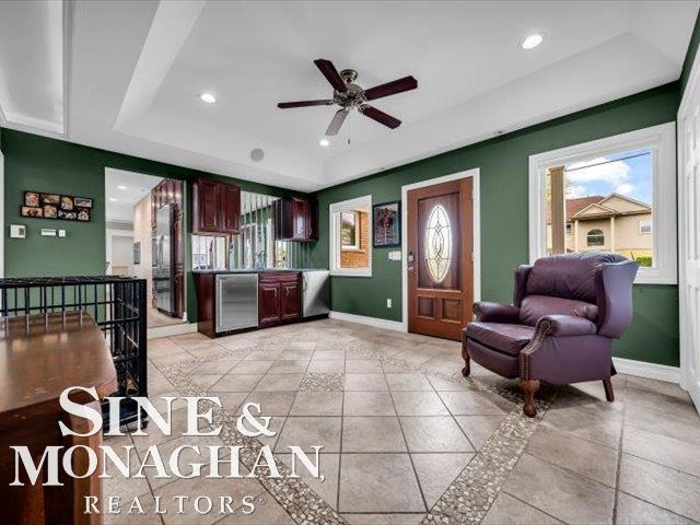 entryway with a tray ceiling, baseboards, a ceiling fan, light tile patterned flooring, and recessed lighting