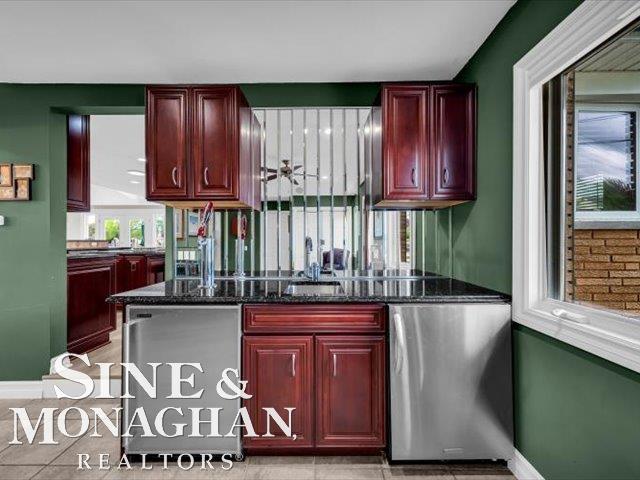 bar featuring dishwasher, baseboards, and light tile patterned floors