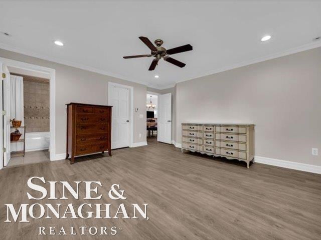 unfurnished bedroom with ornamental molding, baseboards, wood finished floors, recessed lighting, and ensuite bathroom