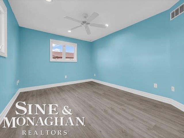 empty room featuring a ceiling fan, wood finished floors, baseboards, and recessed lighting