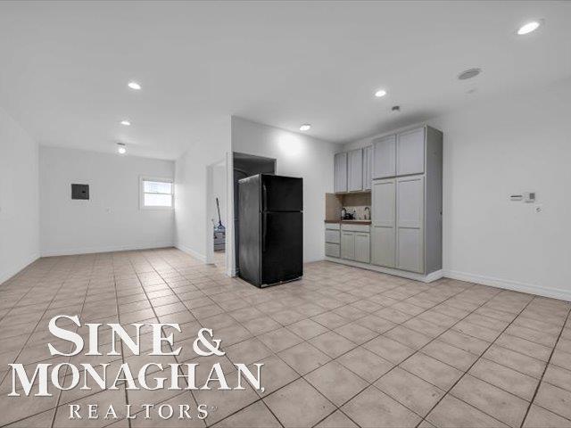kitchen with freestanding refrigerator, gray cabinets, recessed lighting, light tile patterned floors, and baseboards