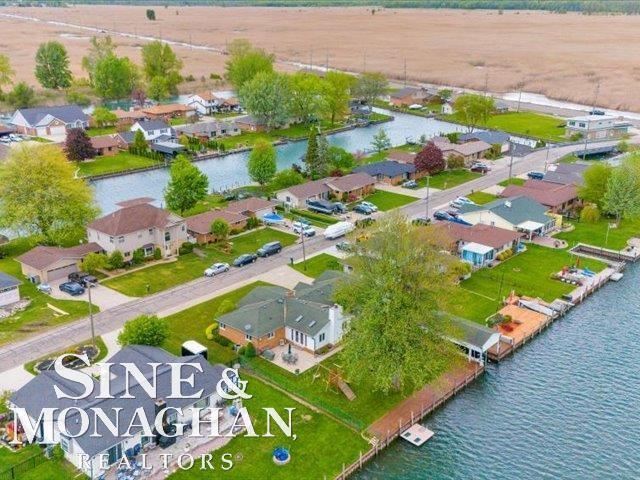 aerial overview of property's location with nearby suburban area and a nearby body of water