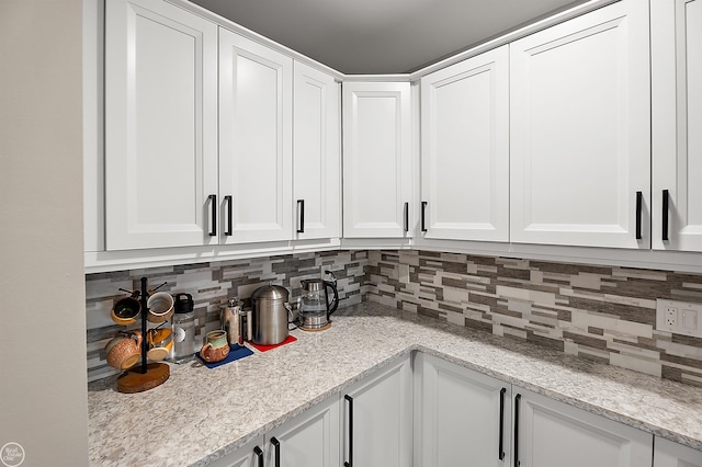 2102 Pauline Blvd Unit 304, Ann Arbor, MI 48103 - kitchen with backsplash, white cabinetry, and light stone counters