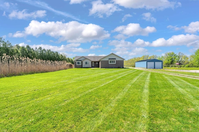 view of green lawn featuring driveway, an outdoor structure, and a garage