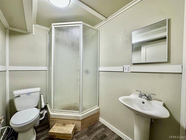 518 Lynn St, Munising, MI 49862 - full bathroom with wood finished floors, a shower stall, toilet, and baseboards
