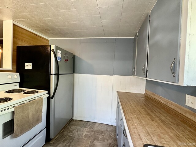 518 Lynn St, Munising, MI 49862 - kitchen featuring electric stove, butcher block counters, and wooden walls