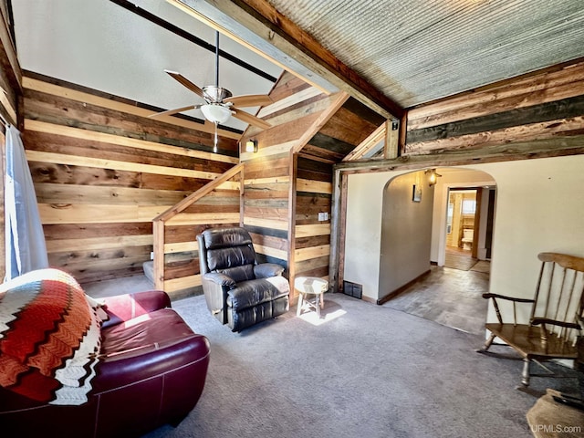 518 Lynn St, Munising, MI 49862 - living area featuring wood walls, arched walkways, a ceiling fan, lofted ceiling, and carpet floors
