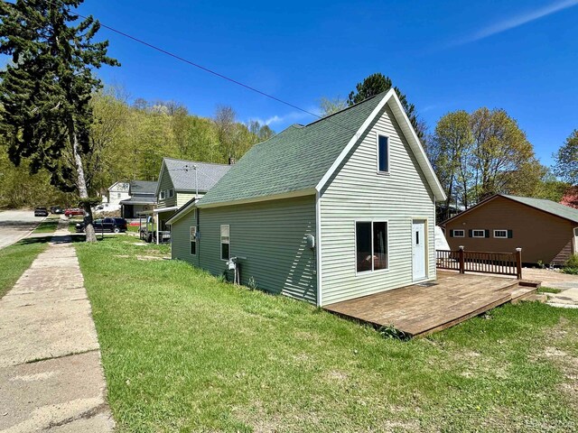 518 Lynn St, Munising, MI 49862 - view of property exterior featuring a deck, a yard, and a shingled roof