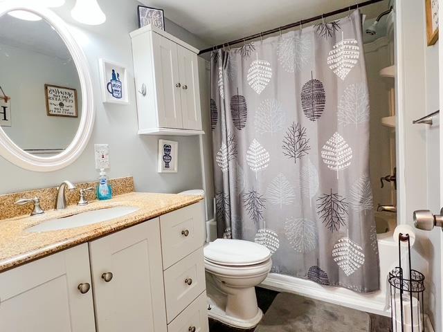 601 N Scott Dr, Farwell, MI 48622 - full bathroom featuring vanity, toilet, and shower / tub combo with curtain