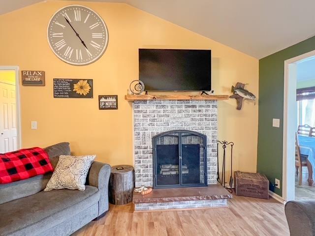 601 N Scott Dr, Farwell, MI 48622 - living room featuring vaulted ceiling, wood finished floors, and a fireplace