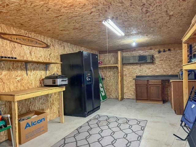 601 N Scott Dr, Farwell, MI 48622 - kitchen with black fridge with ice dispenser and concrete flooring