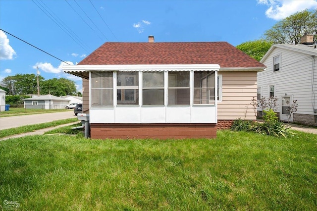 7003 Paige Ave, Warren, MI 48091 - back of house featuring a sunroom, a shingled roof, a yard, and a chimney