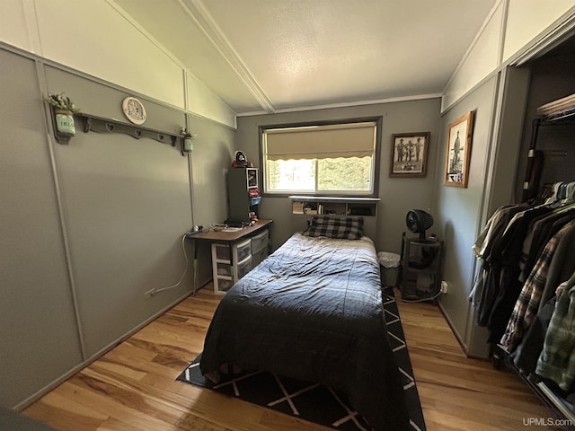 381 Mangum Rd, Marquette, MI 49855 - bedroom with wood finished floors, vaulted ceiling, and crown molding