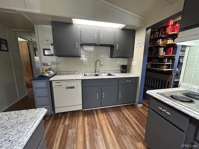 381 Mangum Rd, Marquette, MI 49855 - kitchen featuring dishwasher, a sink, dark wood-style flooring, tasteful backsplash, and light countertops
