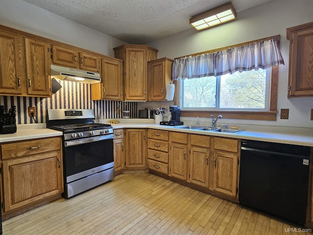 120 N Pewabic St, Laurium, MI 49913 - kitchen with stainless steel gas stove, dishwasher, under cabinet range hood, a sink, and light countertops