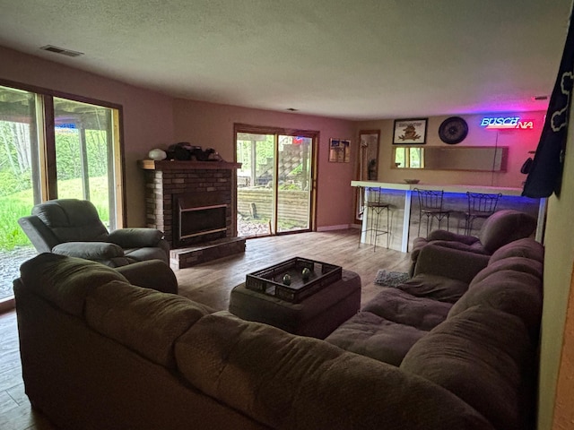2913 W Howard Rd, Beaverton, MI 48612 - living area with a bar, wood finished floors, a fireplace, and baseboards