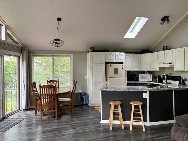 2913 W Howard Rd, Beaverton, MI 48612 - kitchen featuring white appliances, under cabinet range hood, lofted ceiling, crown molding, and a skylight