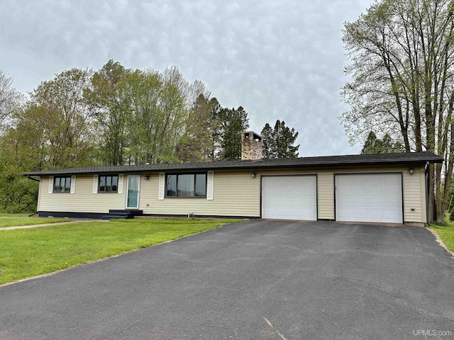 725 N Luxmore St, Ironwood, MI 49938 - ranch-style home with driveway, a chimney, an attached garage, and a front lawn